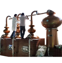 two workers stand on the base of triple pot still distiller